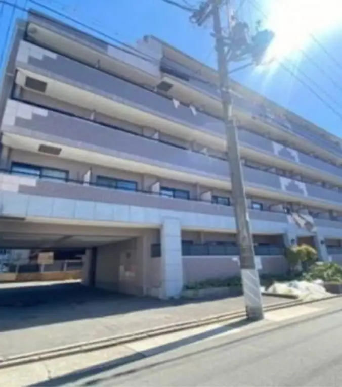 シンプルなデザインの5階建てマンションで、日差しが強く晴天の中撮影された外観
                                                