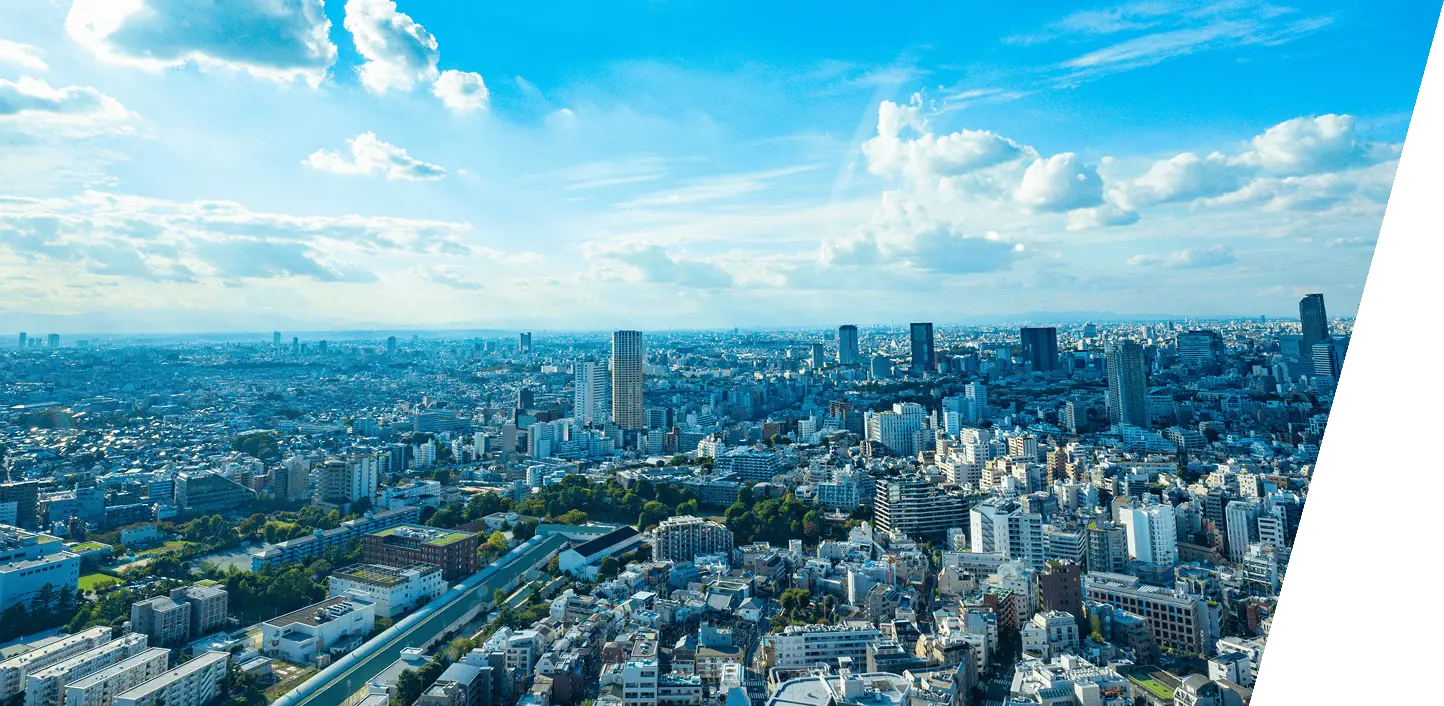 都市全体を見渡す高所からの眺望写真で、高層ビルや住宅が広がる都会的な景色が一望できる